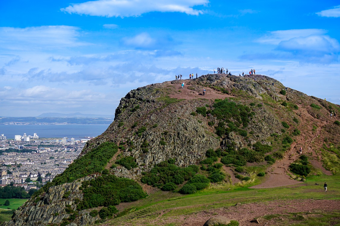 Hikers on Arthur's Seat looking down upon the Edinburgh Festival in Scotland