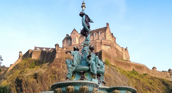 View of Edinburgh Castle in front of Ross Fountain in Princes Street Gardens