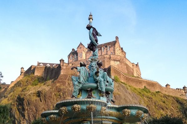 View of Edinburgh Castle in front of Ross Fountain in Princes Street Gardens