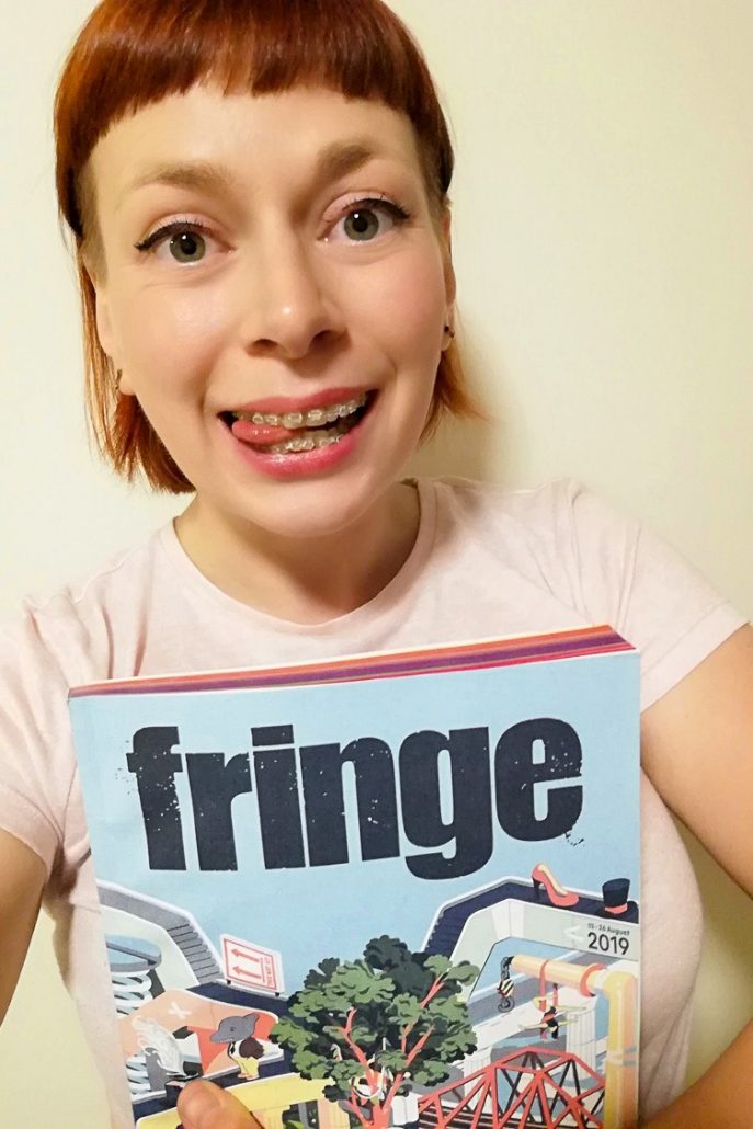 Alice Teacake holding the Fringe Festival programme guide