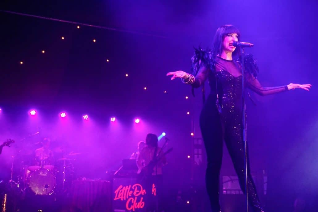 Lady in black sequinned jumpsuit opening the Little Death Club cabaret