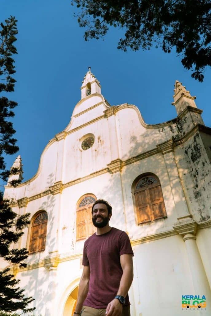 My friend walking away with the aged, white St. Francis Church standing tall behind him