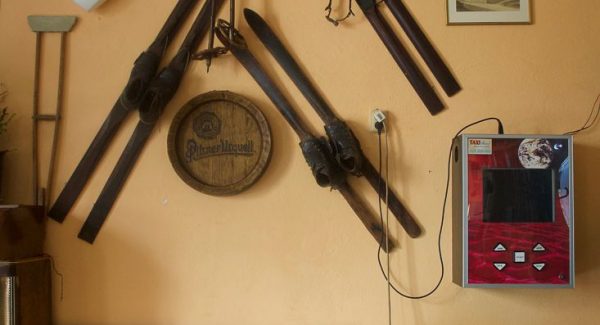 Photo inside a chalet showing some vintage ski equipment that is hung on the wall as well as an old foosball table in front.