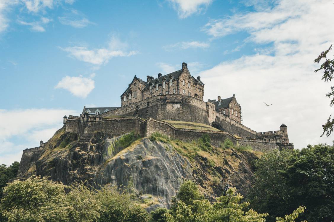 Photo of Edinburgh Castle with blue skies and white fluffy clouds in the background
