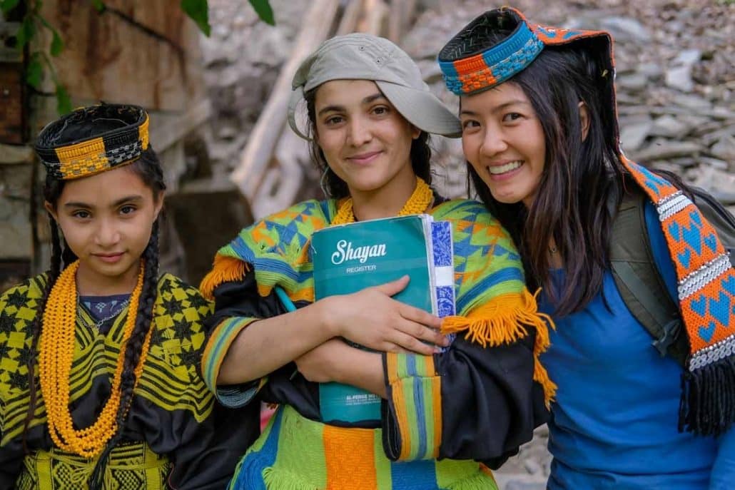 Photo of three women, two from Pakistan wearing traditional Kalash dress