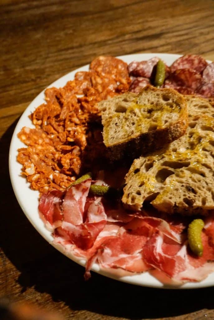 A big plate of Wage beef and British chorizo with servings of bread and pickles can experienced in restaurants in Leeds City Centre