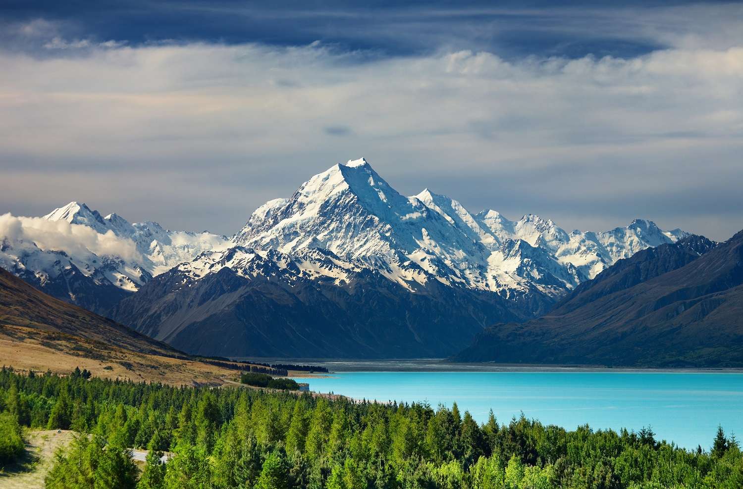 A beautiful view of Mount Cook and Pukaki Lake in New Zealand with blue water and snow-capped mountains